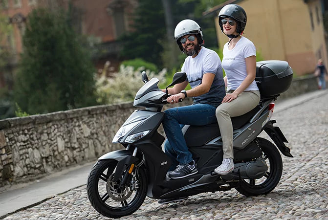 Couple riding a scooter in Aegina on an island road